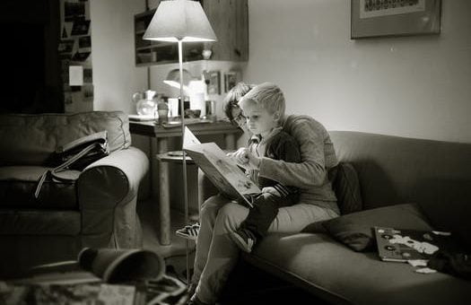 reading to a kid black and white photo | Lift Legal