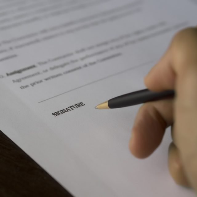 signing paper document | Lift Legal